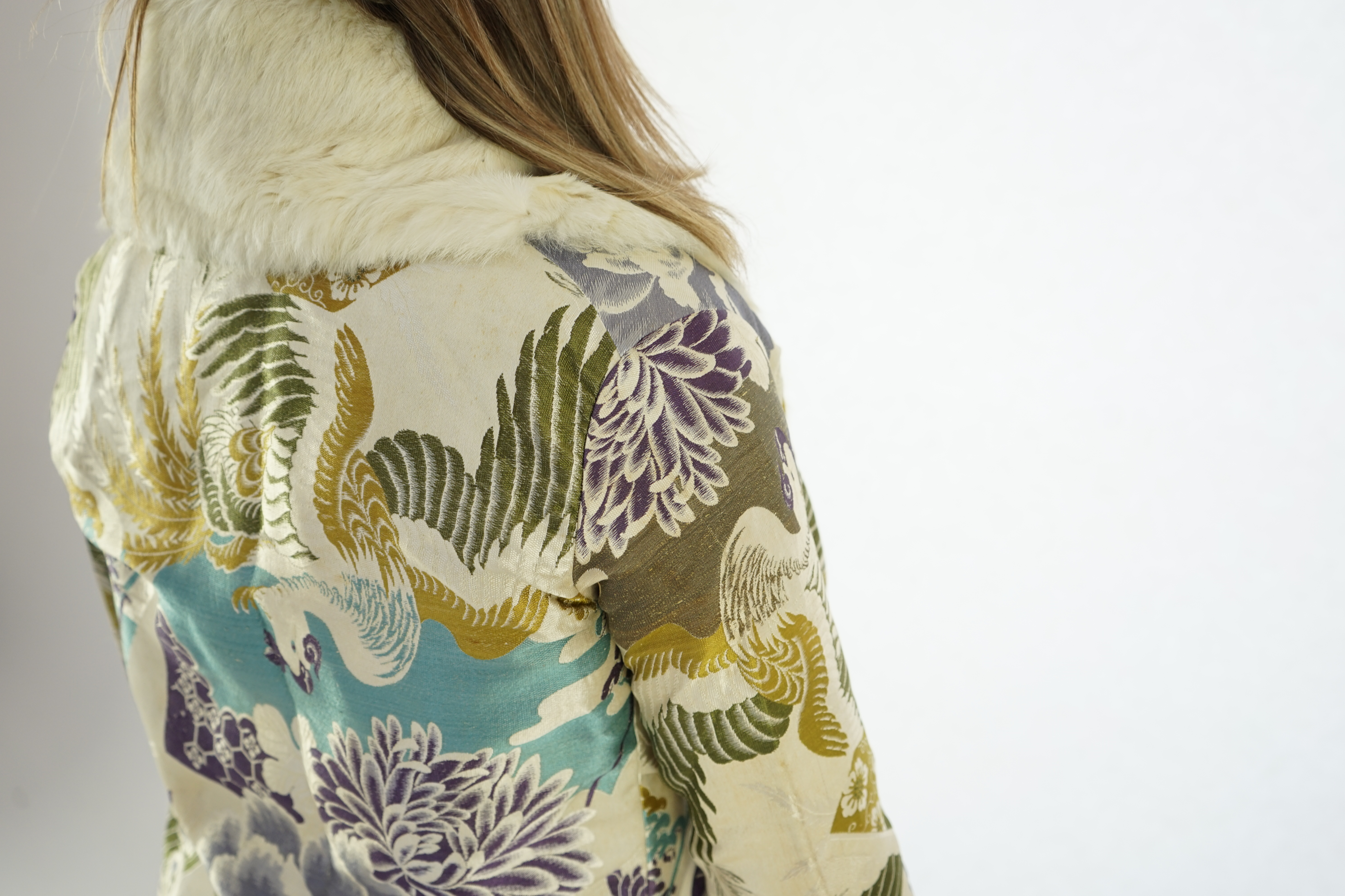 A 1940's lady's patterned brocade evening coat with white fur trim.
